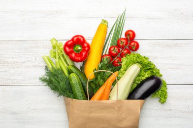 Beyaz ahşap bir arka planda kağıt bir torba içindeki ürünler. Süpermarketten ya da marketten alışveriş yapmak