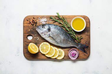 Limon ve baharatlarla hazırlanmış kesme tahtasındaki taze dorado. Üst görünüm.