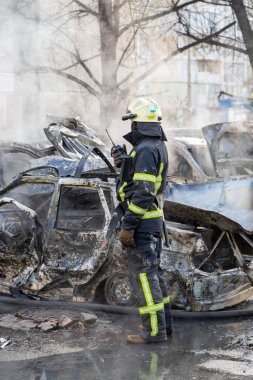 Kiev 'in bombalanması sonucu yanan arabalar. Rus ordusunun Ukrayna 'ya karşı saldırısı. Kyiv yerleşim bölgesine füze saldırısı. Sivillerin bombalanması.