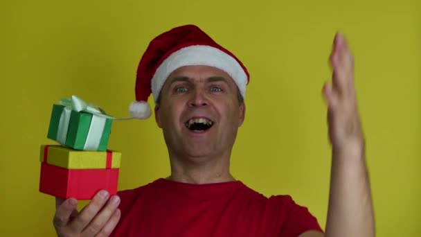 Portret van een gelukkige oudere man die een kerstgeschenkdoos presenteert. — Stockvideo