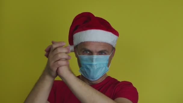 Emotional man in Santa hat applauds with his hands. — Stock Video