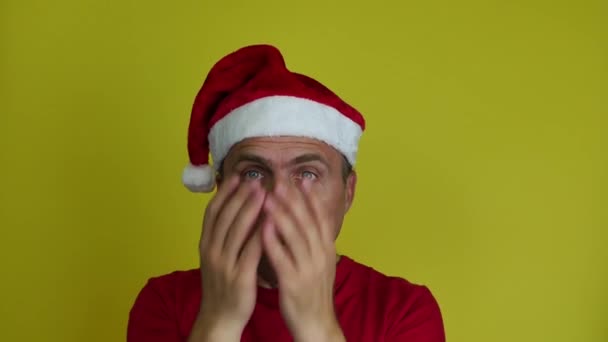 De man met de kerstmuts is verrast en bang.. — Stockvideo