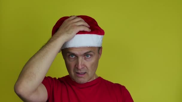 Een radeloze, geschokte oudere man met een kerstmuts op is woedend.. — Stockvideo