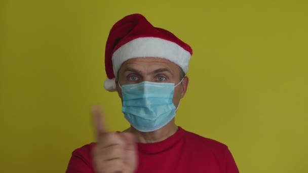 一个戴着圣诞老人帽和面具的男人交叉着胳膊，以手势拒绝和禁止. — 图库视频影像