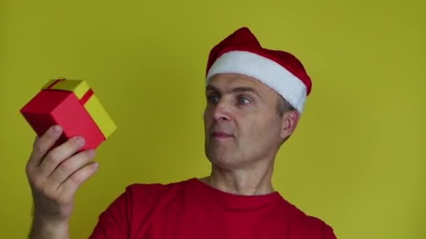 Porträt eines glücklichen älteren Mannes, der eine Weihnachtsgeschenkschachtel präsentiert. — Stockvideo