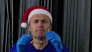 Noel Baba şapkalı yakışıklı adam gözlük takıyor..