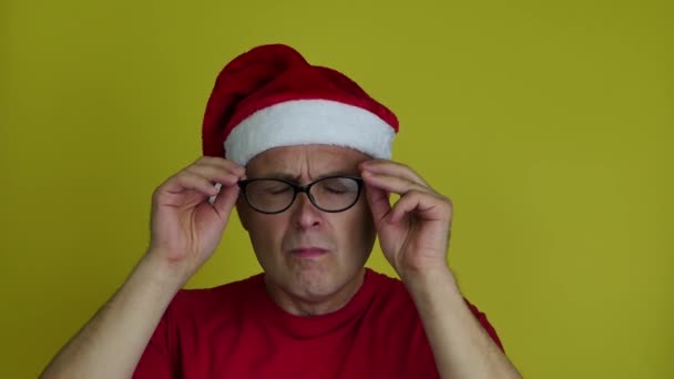 De man met de kerstmuts doet zijn bril af als een verrassing.. — Stockvideo