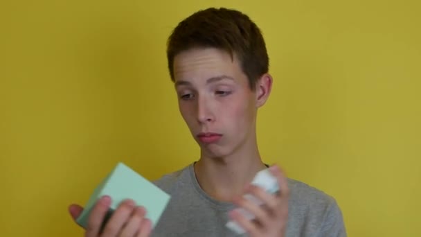 Adolescente en camiseta gris sosteniendo una caja de regalo. — Vídeos de Stock