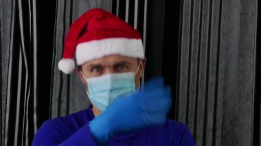 Noel Baba şapkalı bir adam elleriyle davetiye çıkarıyor..