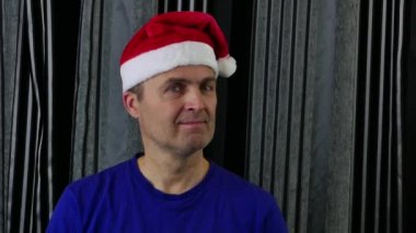 Noel Baba şapkalı adam başını farklı yöne çeviriyor..