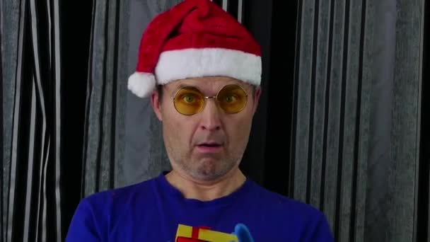 Чоловік у капелюсі Санта зловив падаючу подарункову коробку . — стокове відео