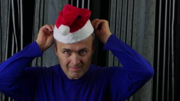 Przystojny mężczyzna zakłada kapelusz Świętego Mikołaja i robi aprobatę.. — Wideo stockowe