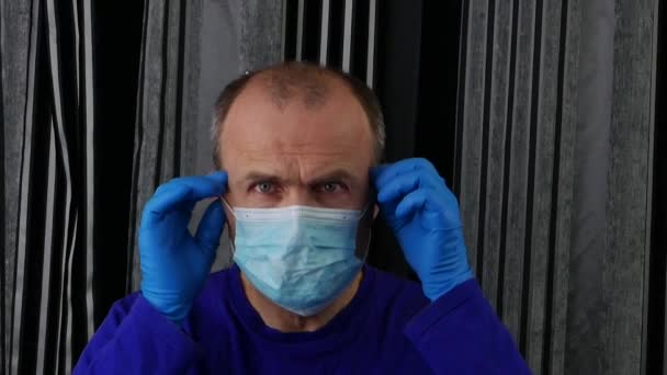 Мужчина в синей футболке с облегчением снимает свою медицинскую маску . . — стоковое видео