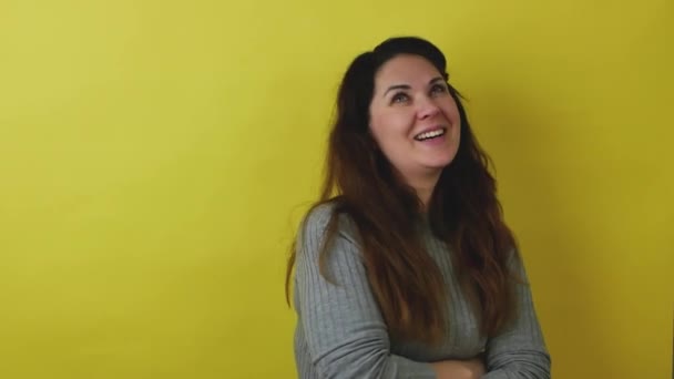 Beautiful woman on a yellow background shows the emotion of embarrassment. — Stock Video