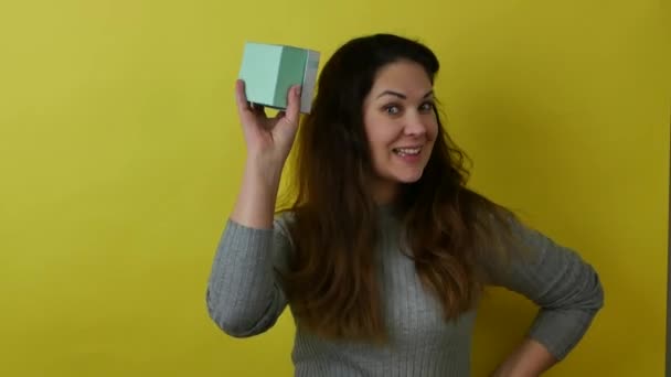 Hermosa mujer alegre mostrando una caja de regalo azul en sus manos — Vídeos de Stock