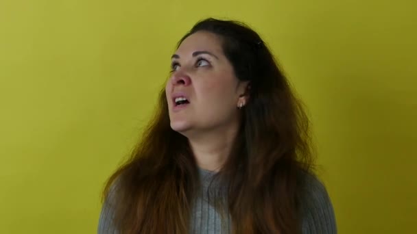 Beautiful woman on a yellow background in a state of anger and aggression. — Stockvideo