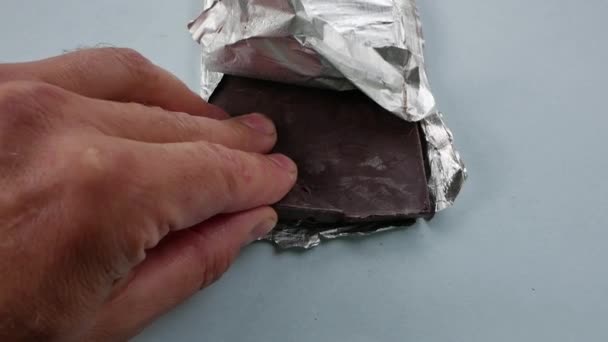 Los dedos rompen un pequeño trozo de la barra de chocolate. — Vídeos de Stock