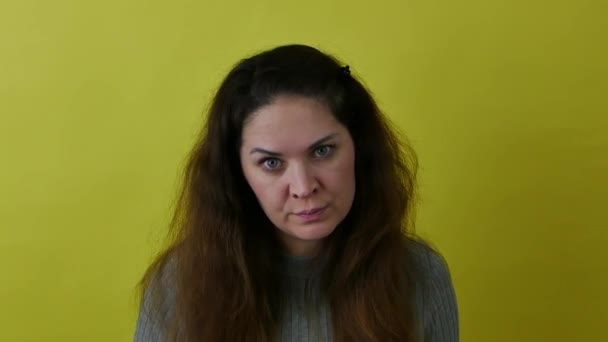 Schöne Frau auf gelbem Hintergrund in einem Zustand der Wut und Aggression. — Stockvideo