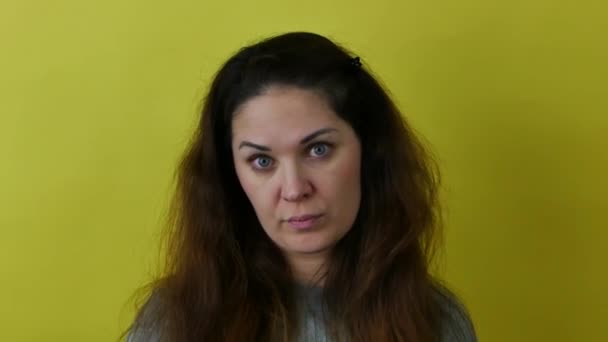 Portrait of a surprised sarcastic woman on yellow background. — стоковое видео