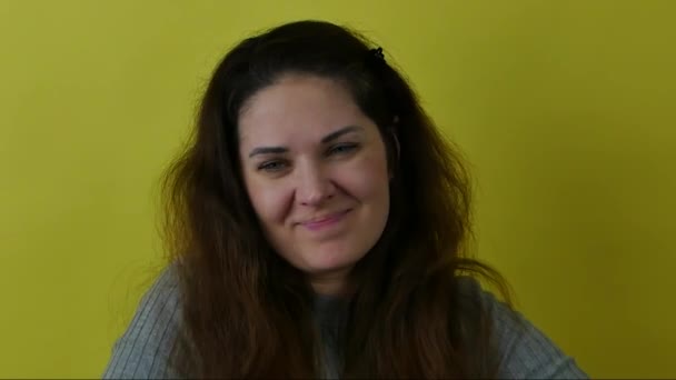 Портрет усміхненої сором'язливої дівчини на жовтому тлі . — стокове відео