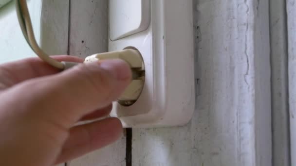 Egy férfi kézzel húzza ki a dugót a konnektorból.. — Stock videók