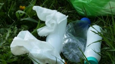 Mavi lastik eldivenli eller plastik şişeleri topluyor..