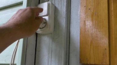 Bir adamın eli prizden bir elektrik prizi çıkarır ve başka bir priz yerleştirir..