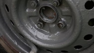 El fırçayla arabanın tekerleğini boyuyor.. 