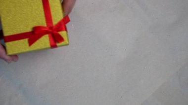 Erkek el, hediye kutusunu kağıt arkaplana yerleştirir.