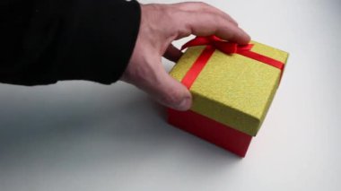 Eller beyaz arkaplanda çok renkli hediye kutularını gösterir.