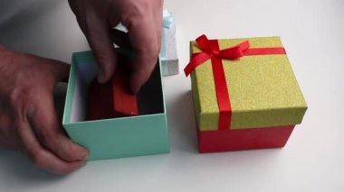 Eller kutuların kapaklarını açar ve hediyeleri alır..