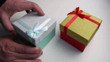 Erkekler hediye kutusunu açar ve küçük kutuları çıkarır..