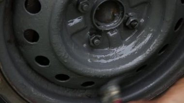 El fırçayla arabanın tekerleğini boyuyor.. 