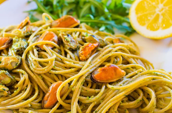 Espaguete com carne de mexilhões e pesto — Fotografia de Stock