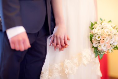 Gelin ve damat el ele tutuşuyorlar.
