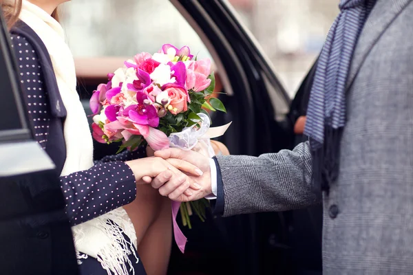 O cara dá a menina um buquê de flores — Fotografia de Stock