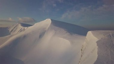Güneşin doğuşunda, dağ karla kaplı tepenin havadan görünüşü