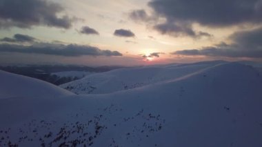 Gün batımında, dağ karla kaplı tepenin havadan görünüşü