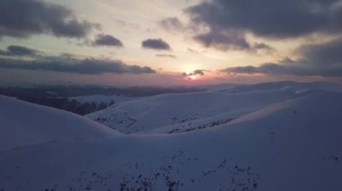 Gün batımında, dağ karla kaplı tepenin havadan görünüşü