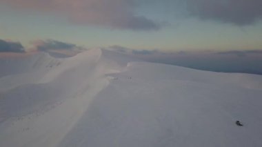 Güneşin doğuşunda, dağ karla kaplı tepenin havadan görünüşü