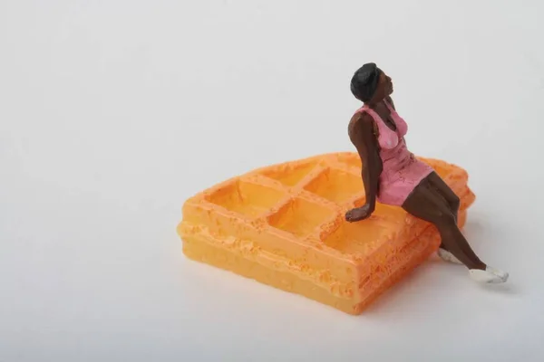 Miniature Figurine Black Woman Sitting Giant Waffle — Stock Photo, Image