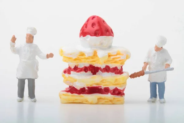 Minyatür Bir Aşçı Figürü Dev Bir Pasta Hazırlıyor — Stok fotoğraf