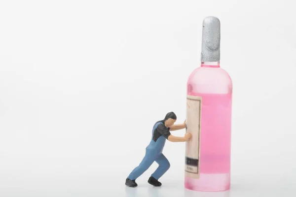 Figurilla Miniatura Hombre Empujando Una Botella Bebida Alcohólica —  Fotos de Stock