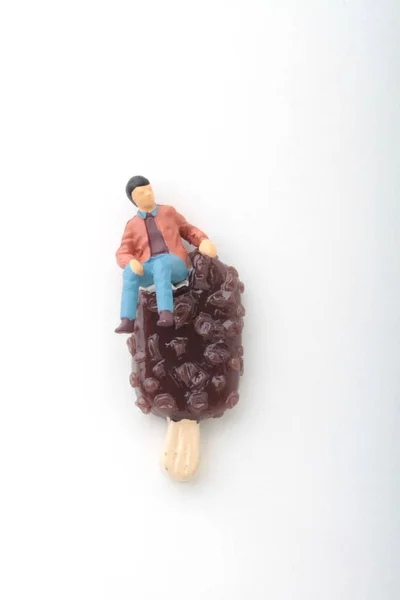 Estatueta Miniatura Homem Sentado Sorvete Chocolate Gigante — Fotografia de Stock