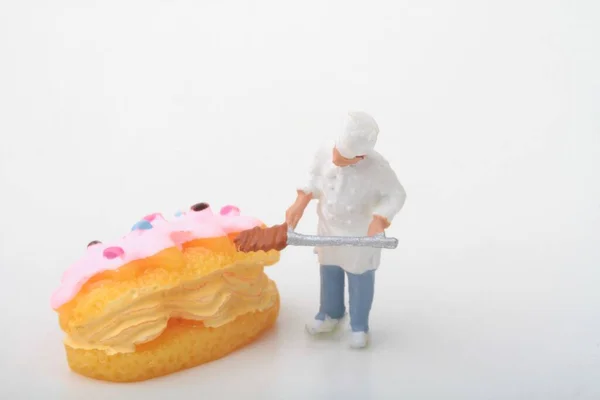 Miniature Figurine Cook Preparing Giant Cream Pastry — Stock Photo, Image