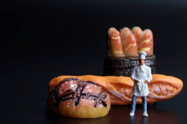 Bir fırının üzerinde minyatür bir aşçı figürü ve ekmek.