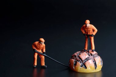 Geleneksel fırın yemekleriyle çalışan bir erkek takımının minyatür figürleri.