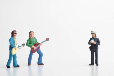 Birkaç sokak müzisyenine ceza kesen bir polis memurunun minyatür figürü.