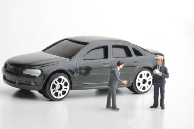 Bir polis memurunun minyatür biblosu araba şoförüne ceza kesiyor. 