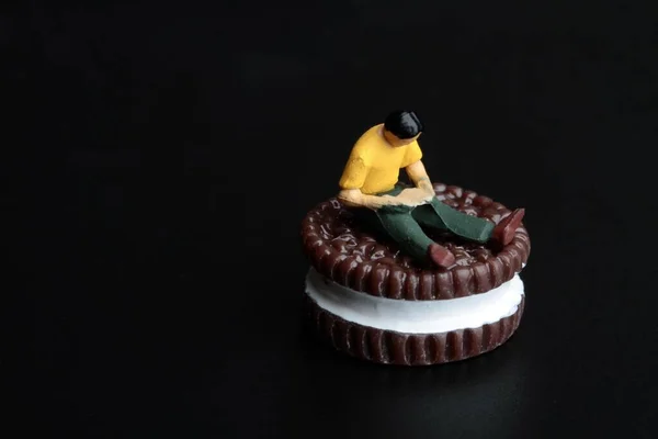 Miniature Figurine Man Sitting Huge Stuffed Biscuit — 스톡 사진